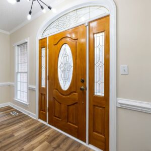 a wood door and side panels with glass inlays