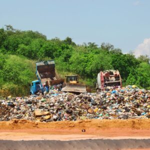 trucks dumping trash in a landfill