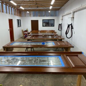 a row of different front doors on saw horses being restored