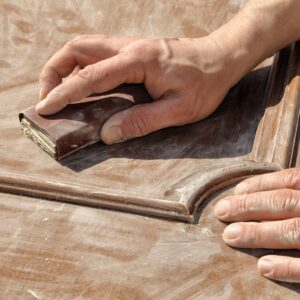 person sanding wood detail