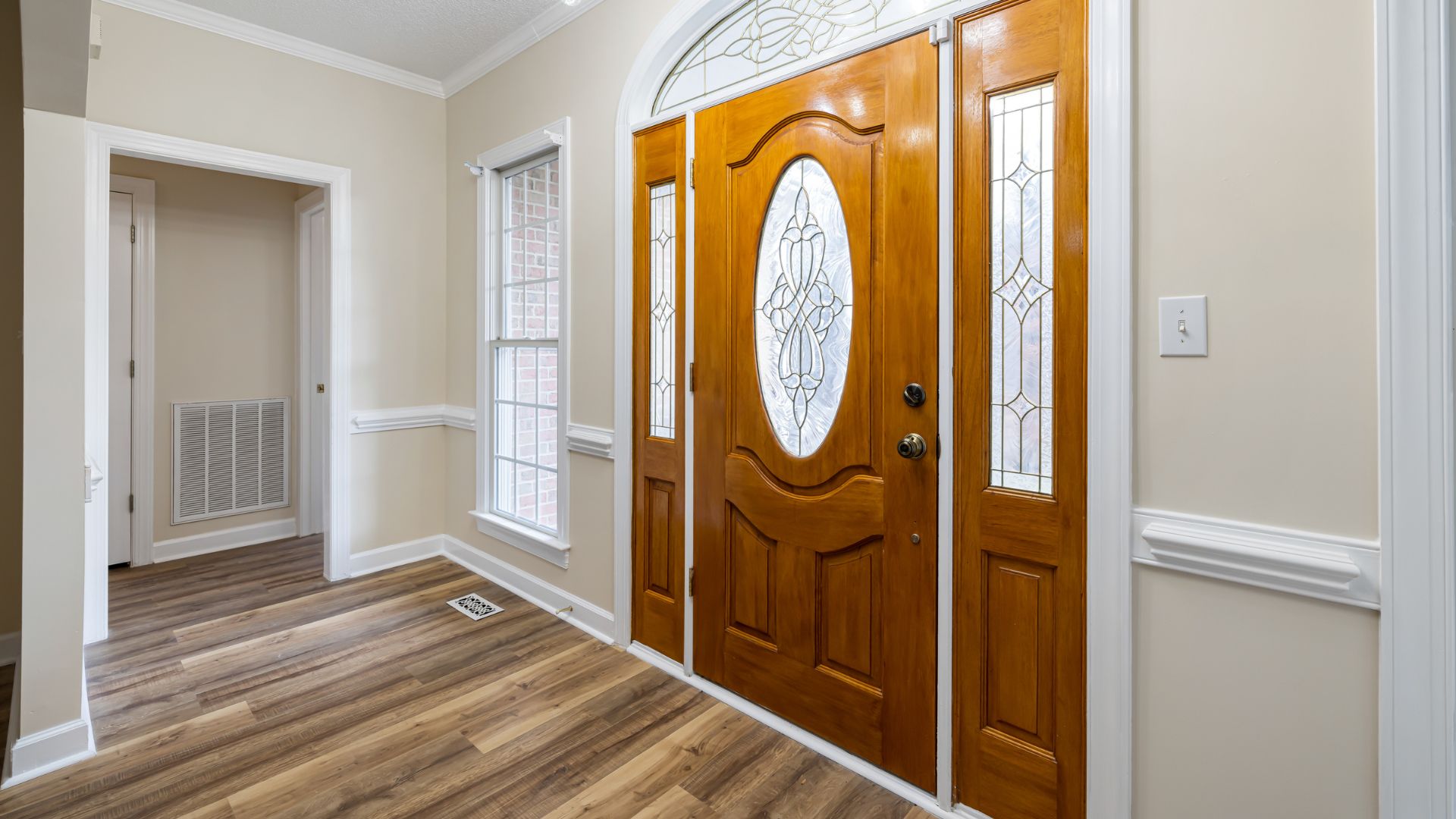 Interior view of a wooden front door with glass accent window