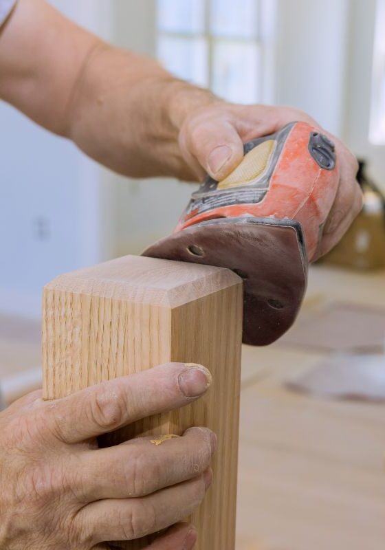 man sanding table leg